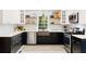 Stylish kitchen with black and white floors, floating shelves, and stainless steel appliances at 6005 Cherecobb Ln, Woodstock, GA 30188