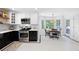 Charming kitchen with black and white checkerboard floor, stainless steel appliances, and breakfast nook at 6005 Cherecobb Ln, Woodstock, GA 30188