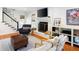 Cozy living room featuring a fireplace, hardwood floors, and a staircase nearby at 6005 Cherecobb Ln, Woodstock, GA 30188