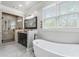 Bright bathroom featuring a soaking tub, glass shower, dark vanity, and tile flooring at 631 Boulevard Ne, Atlanta, GA 30308