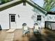 Back deck with two Adirondack chairs and a view of the white exterior of the home at 319 Primrose Ln, Auburn, GA 30011