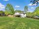 Sprawling backyard with a white home, steps leading to deck, and lush green lawn at 319 Primrose Ln, Auburn, GA 30011