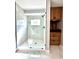 Stylish walk-in shower features glass enclosure, marble tile, and a mounted television at 319 Primrose Ln, Auburn, GA 30011
