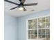 A light-filled bedroom features light blue walls, a window and a black ceiling fan at 319 Primrose Ln, Auburn, GA 30011