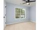 A cozy bedroom with blue walls, neutral carpet and a modern ceiling fan at 319 Primrose Ln, Auburn, GA 30011