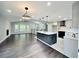 Modern living area featuring hardwood floors, stylish lighting, a stone fireplace, and an open kitchen design at 319 Primrose Ln, Auburn, GA 30011