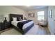 Well-lit bedroom with stylish gray furnishings, carpet, and art prints creating a relaxing atmosphere at 3690 Summerpoint Xing, Cumming, GA 30028