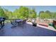 Spacious deck featuring a grill, outdoor seating, a fire pit, and lush green scenery in the background at 3690 Summerpoint Xing, Cumming, GA 30028