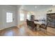 An open and inviting dining area with wood floors, a dining table, and a decorative entry door at 3690 Summerpoint Xing, Cumming, GA 30028