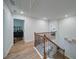 Upstairs hallway featuring wood floors, a staircase with metal spindles, and access to multiple rooms at 3690 Summerpoint Xing, Cumming, GA 30028