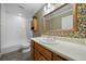 Traditional bathroom featuring a white vanity, floral wallpaper, tub and decorative gold-trimmed mirror at 4512 Terret Nw Trce, Acworth, GA 30101