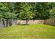 Large backyard with healthy green grass and a wooden fence surrounding the perimeter at 458 Burgundy Se Ter, Atlanta, GA 30354