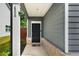 Inviting front porch with a black front door, brick accents, and gray siding at 458 Burgundy Se Ter, Atlanta, GA 30354