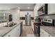 Bright kitchen with granite counters, stainless appliances, undermount sink, and white cabinets at 458 Burgundy Se Ter, Atlanta, GA 30354