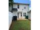 View of the backyard with white fence and partial lawn featuring back entrance to the home at 5897 Strathmoor Manor Cir, Lithonia, GA 30058