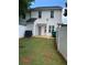 View of the backyard with white fence and partial lawn featuring back entrance to the home at 5897 Strathmoor Manor Cir, Lithonia, GA 30058