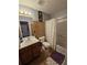 Functional bathroom with a vanity, toilet, and shower-tub combination with decorative curtain at 5897 Strathmoor Manor Cir, Lithonia, GA 30058