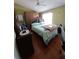 Cozy bedroom features classic furniture, a queen bed with a plaid comforter and wood floors at 5897 Strathmoor Manor Cir, Lithonia, GA 30058