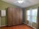 Bedroom with wood floors, a large closet, and windows, offering comfort and storage at 5897 Strathmoor Manor Cir, Lithonia, GA 30058