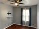 A cozy bedroom featuring hardwood floors, a ceiling fan, and a window for natural light at 5897 Strathmoor Manor Cir, Lithonia, GA 30058