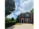 Red brick townhome with a well-manicured front lawn, and a decorative front door entryway at 5897 Strathmoor Manor Cir, Lithonia, GA 30058