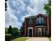 Brick townhome boasts green shutters, a bay window, and a meticulously kept front yard, combining charm and curb appeal at 5897 Strathmoor Manor Cir, Lithonia, GA 30058