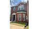 All-brick townhome with green shutters, decorative entry, a bay window, and manicured lawn at 5897 Strathmoor Manor Cir, Lithonia, GA 30058
