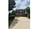 Brick townhome featuring green shutters and a well-maintained lawn. It's a charming place to call home at 5897 Strathmoor Manor Cir, Lithonia, GA 30058