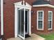 Charming red brick home showcasing an inviting open front door and window, ready for you to move in at 5897 Strathmoor Manor Cir, Lithonia, GA 30058