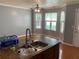 Eat-in kitchen featuring granite countertops, stainless steel sink, and abundant natural light from large windows at 5897 Strathmoor Manor Cir, Lithonia, GA 30058