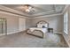 Spacious bedroom features plush carpet, neutral walls, tray ceiling with fan, and large windows at 3419 Mulberry Cove Way, Auburn, GA 30011