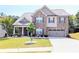 Charming two-story brick home featuring a well-manicured lawn and attached two-car garage at 3419 Mulberry Cove Way, Auburn, GA 30011
