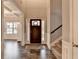 Open foyer with dark wood floors, a staircase, and a glimpse into the bright living spaces at 3419 Mulberry Cove Way, Auburn, GA 30011