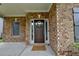 Inviting front porch with a wooden door adorned with a seasonal wreath and stylish shuttered windows at 3419 Mulberry Cove Way, Auburn, GA 30011