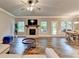 Open living room with a fireplace, hardwood floors, and access to the dining area and backyard at 3419 Mulberry Cove Way, Auburn, GA 30011