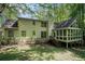 Back exterior view of the home, including a sunroom addition, surrounded by greenery at 1373 Janice Sw Ct, Lilburn, GA 30047