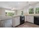 Bright kitchen featuring white cabinets, stainless steel appliances, and an eat-in bar area with hardwood floors at 1373 Janice Sw Ct, Lilburn, GA 30047
