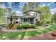 Backyard view showcasing a spacious lawn, stone pathway, wood deck, screened porch and mature landscaping at 1631 Manhasset Dr, Atlanta, GA 30338