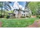 Expansive backyard with lush lawn, stone pathway, mature trees, and a charming screened porch on the house at 1631 Manhasset Dr, Atlanta, GA 30338