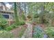 Landscaped backyard with stone pathway leading to a gazebo and a wood deck connected to the home at 1631 Manhasset Dr, Atlanta, GA 30338