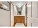 Bright bathroom featuring a wooden vanity, ample lighting, and a large mirror reflecting a glimpse of the bedroom at 1631 Manhasset Dr, Atlanta, GA 30338