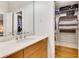 Bathroom showing a wooden vanity with marble countertop and open closet with shelving at 1631 Manhasset Dr, Atlanta, GA 30338