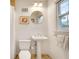 Bright bathroom with a pedestal sink, window, and a classic white toilet at 1631 Manhasset Dr, Atlanta, GA 30338