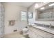 Well-lit bathroom with a white vanity and a shower featuring a patterned curtain at 1631 Manhasset Dr, Atlanta, GA 30338