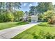 Spacious home featuring an extra long driveway, attached garage, and a lush green lawn at 1631 Manhasset Dr, Atlanta, GA 30338
