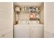 Functional laundry closet equipped with a washer, dryer and storage shelves at 1631 Manhasset Dr, Atlanta, GA 30338