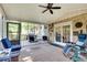 Relaxing sunroom with brick accent wall, ceiling fan, neutral rug, and access to backyard deck area at 1631 Manhasset Dr, Atlanta, GA 30338