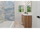 Stylish bathroom with marble flooring, wood vanity, and blue stone tiled shower at 1737 Briarlake Cir, Decatur, GA 30033