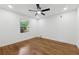 Bright bedroom featuring hardwood floors, white walls, and a modern ceiling fan at 1737 Briarlake Cir, Decatur, GA 30033