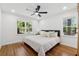 Cozy bedroom with hardwood floors, two windows, a queen bed, and a modern ceiling fan at 1737 Briarlake Cir, Decatur, GA 30033